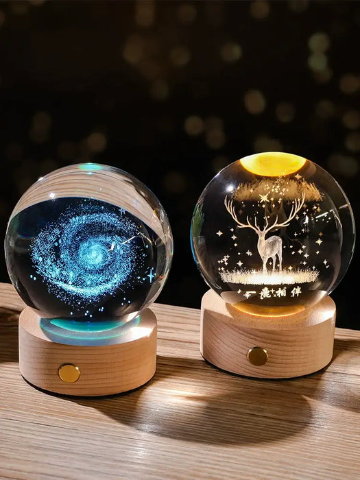 Starry Sky Luminous Ornaments Universe Galaxy Crystal Balls, one with a galaxy design and one with a glowing deer, on wooden bases.