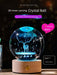 3D inner carving crystal ball with deer design, glowing with romantic light, set on a wooden base.